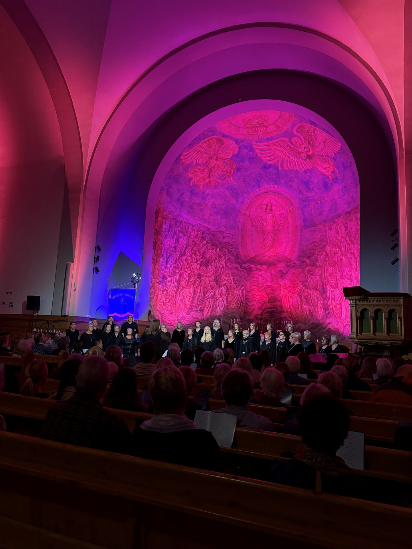 Korkonsert i kirke med rosa og lilla arkitekturlys
